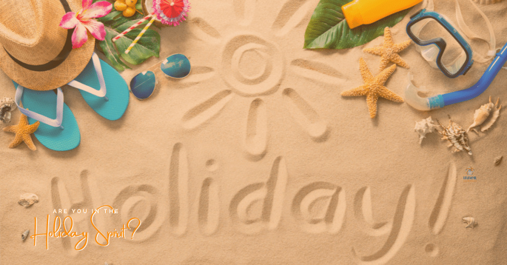 Holiday written on the sand with beach paraphanalia